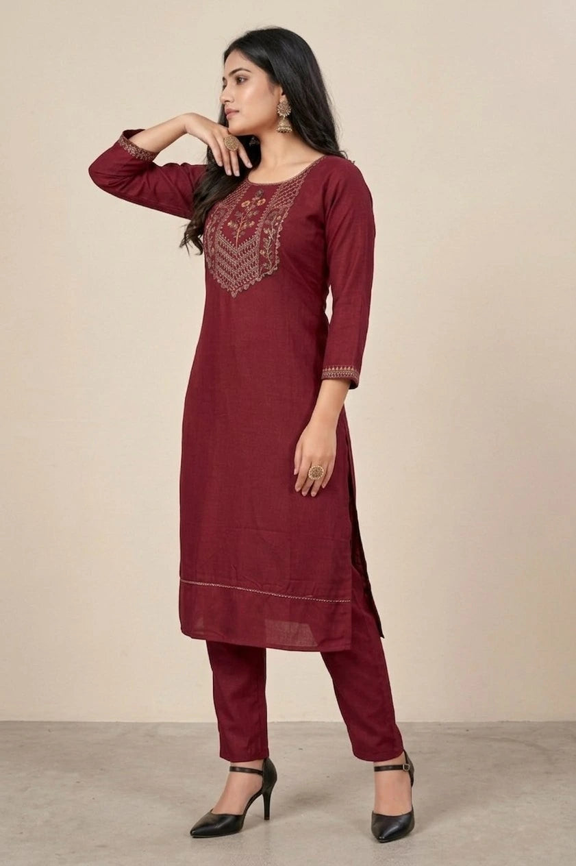 Woman wearing a maroon kurta with embroidery on a beige background